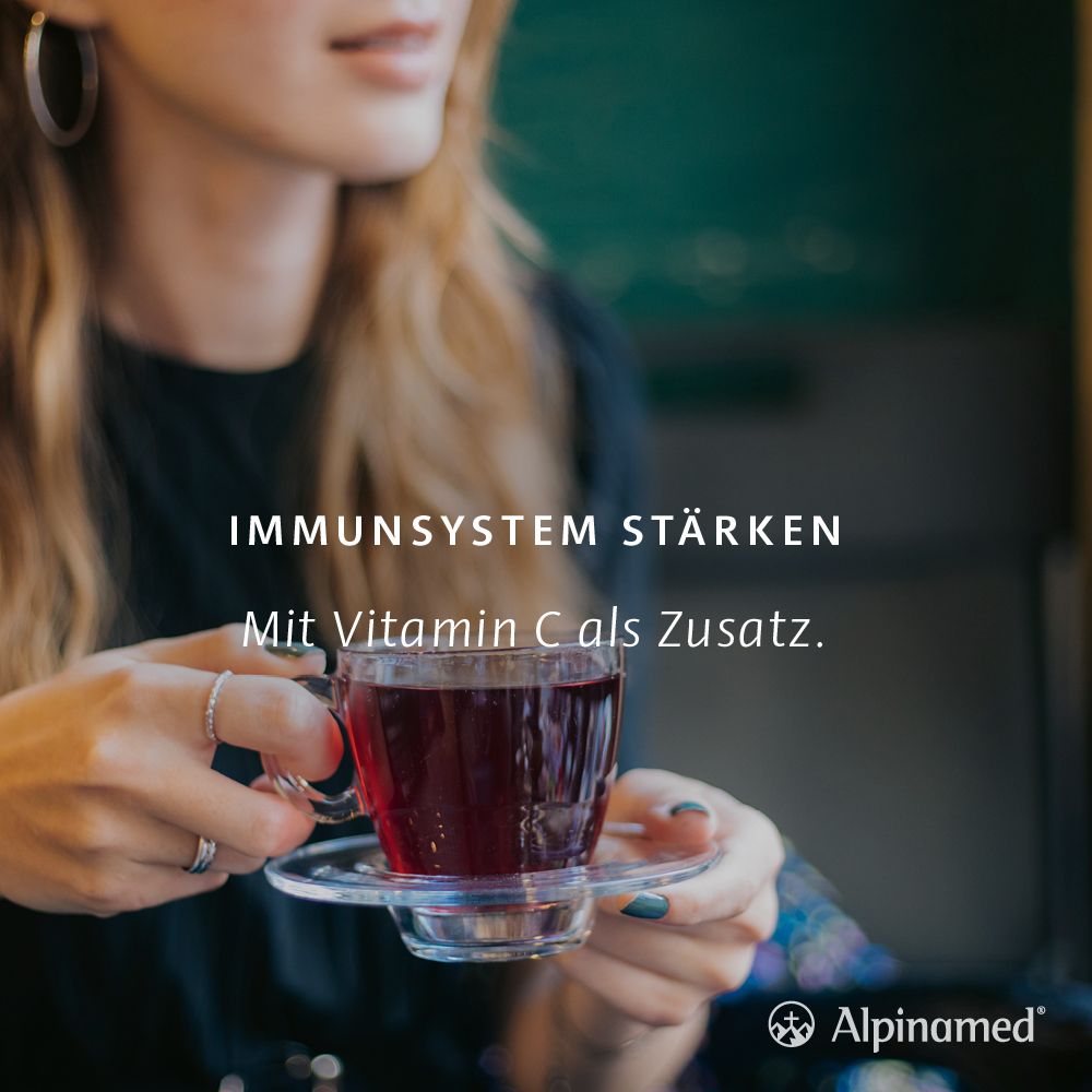 Personne tenant une tasse de thé. Texte : Renforcer le système immunitaire. Logo Alpinamed.