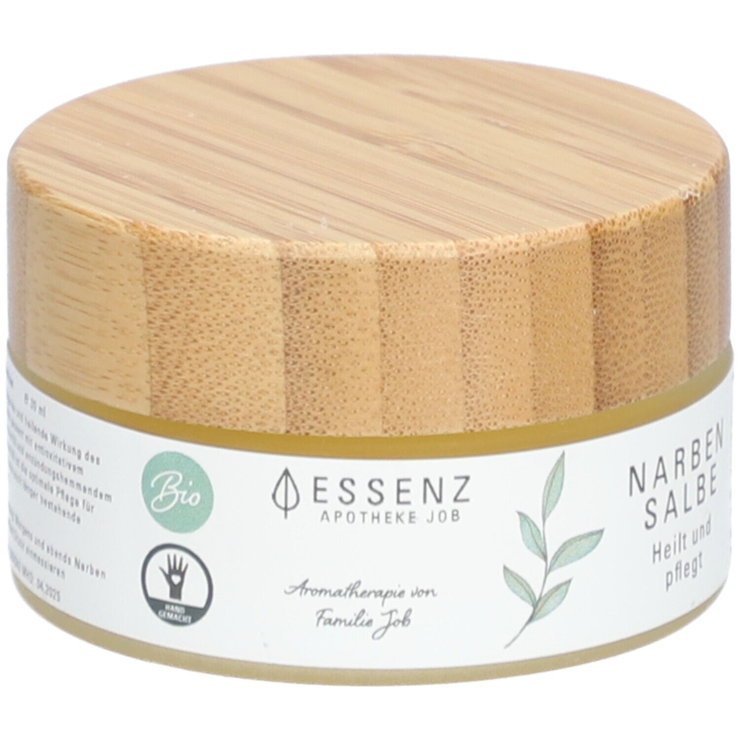 Pot rond avec couvercle en bois. Étiquette "Essenz Narbensalbe". Label bio et symbole de main.