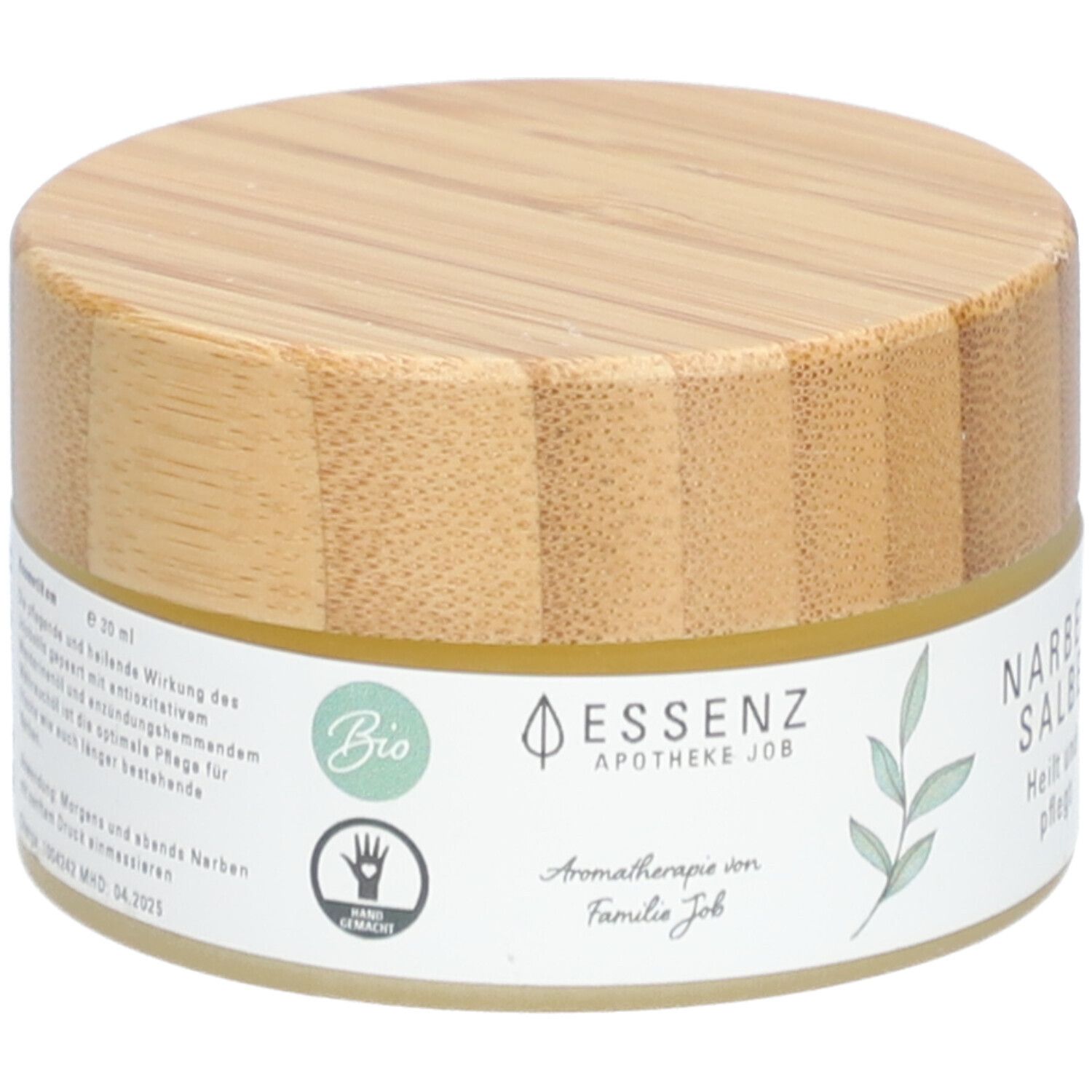 Pot rond avec couvercle en bois. Étiquette "Essenz Narbensalbe". Label bio et symbole de main.