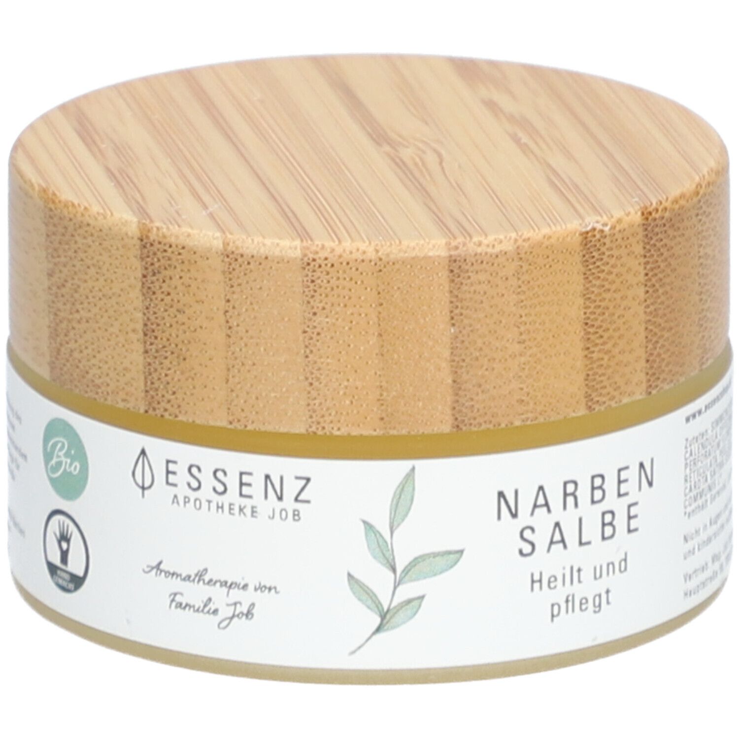 Pot rond avec couvercle en bois. Étiquette "Essenz Narbensalbe". Label bio et symbole de main.