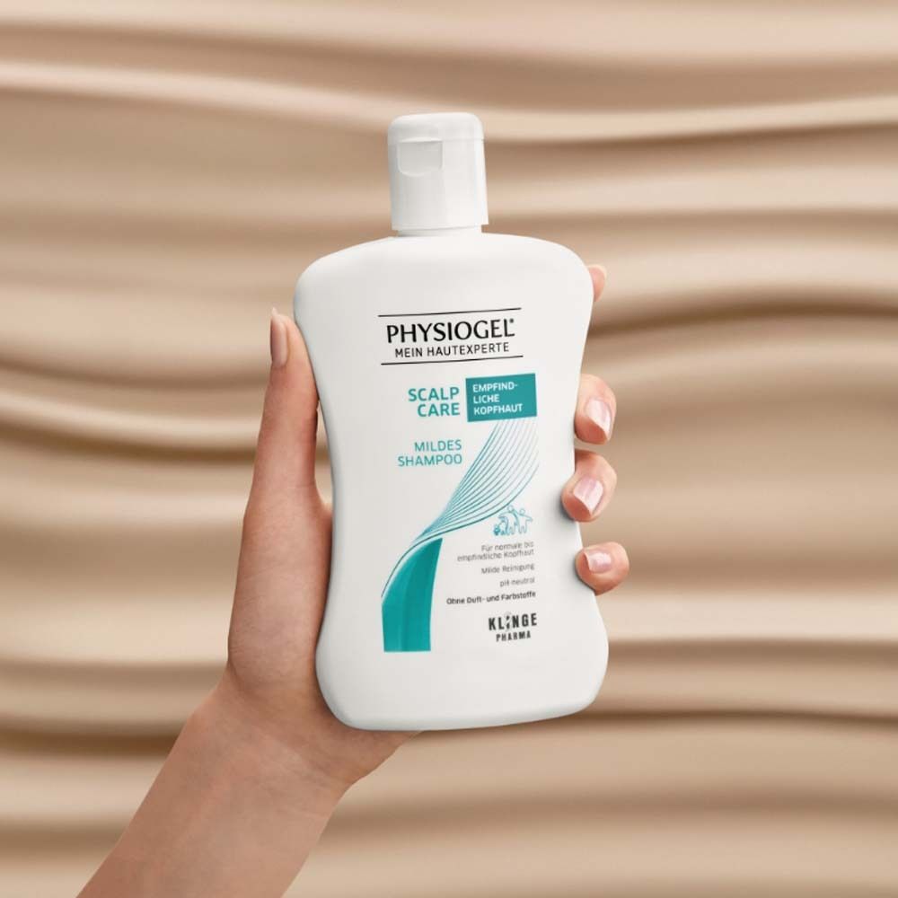 Hand hält Flasche PHYSIOGEL Scalp Care Mildes Shampoo. Aufschrift: Hypoallergen, für empfindliche Kopfhaut. Hintergrund: wellenförmig.