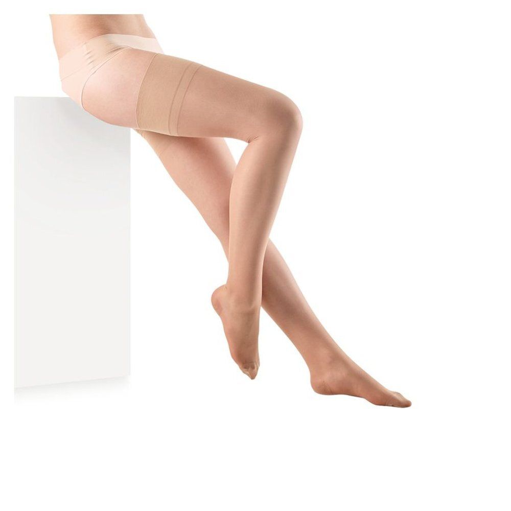 Jambes avec bas remontant jusqu'aux cuisses. Matière couleur chair. Pieds visibles. Sur surface blanche.