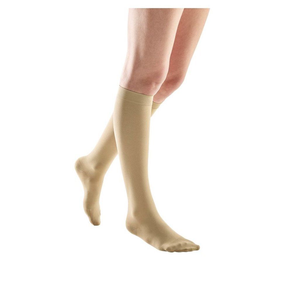 Bas de compression beiges. Vêtement pour les jambes, s'étendant jusqu'au genou. Produit sur fond blanc.