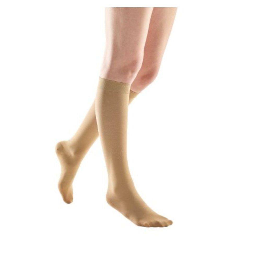 Bas genou beiges. Les bas couvrent les pieds et s'arrêtent sous le genou.