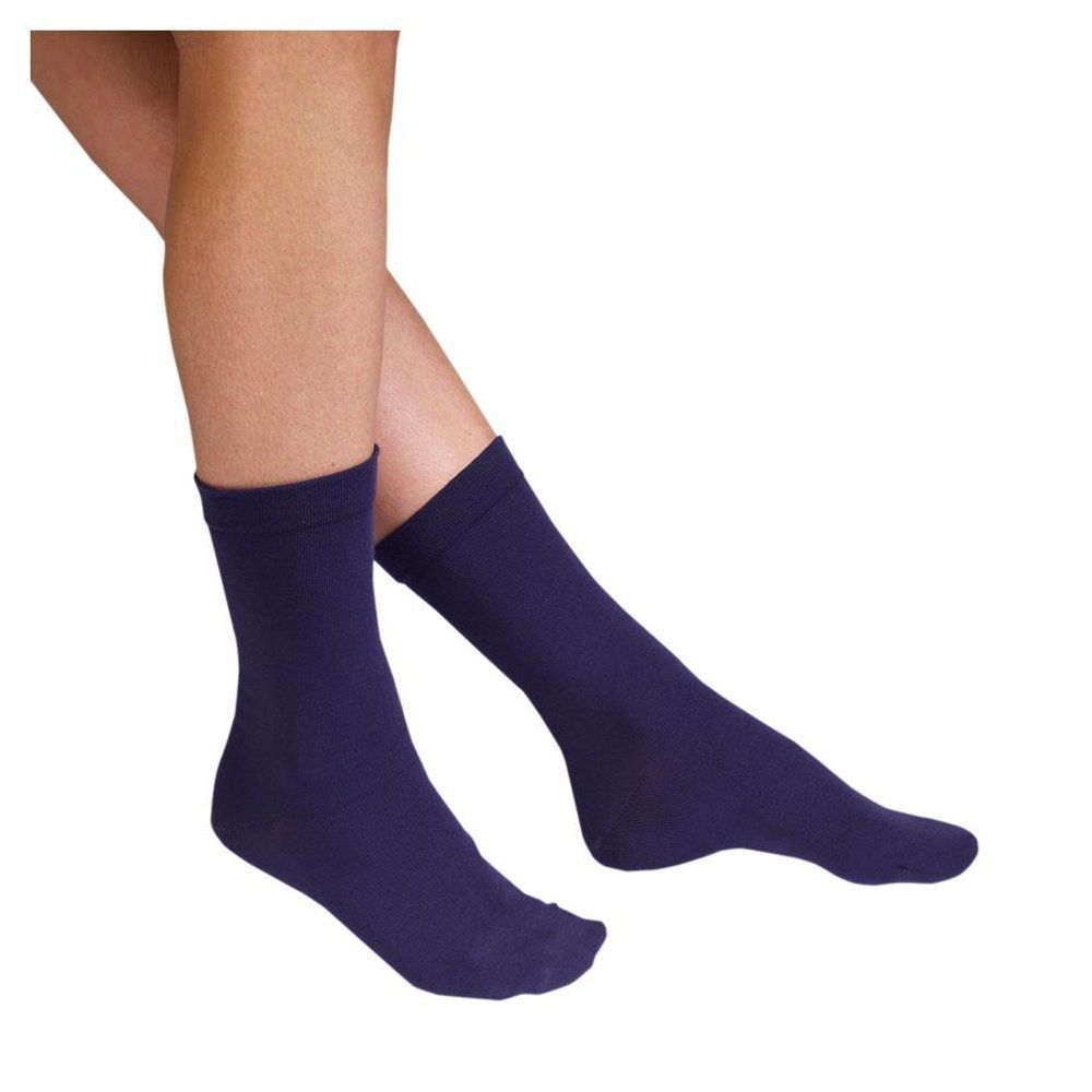 Chaussettes bleues portées sur les jambes. Vue des pieds et des mollets. Tissu lisse.