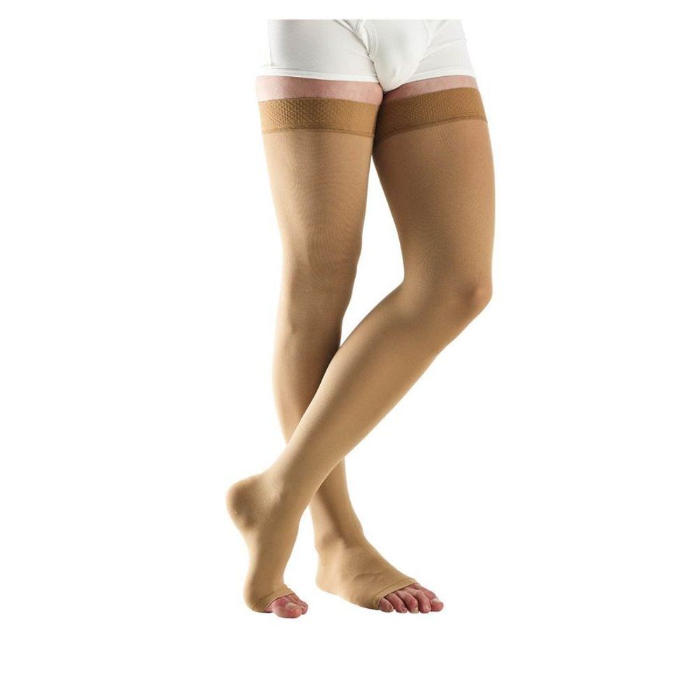 Bas de compression beiges pour hommes. Montants jusqu'aux cuisses avec dentelle. Fond blanc.