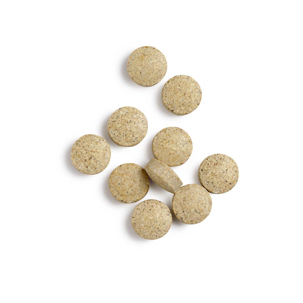 Comprimés ronds beiges. Quelques-uns à côté d'un flacon blanc avec étiquette ADHS®.