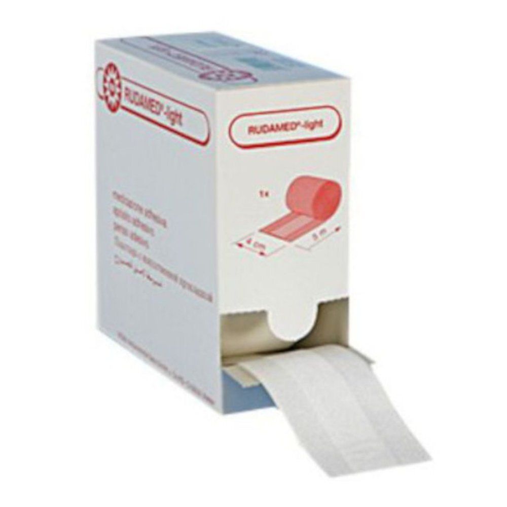 Rouleau de pansement en boîte. Inscription: RUDAMED-light. Dimensions: 4 cm x 5 m. Le pansement sort de l'emballage.