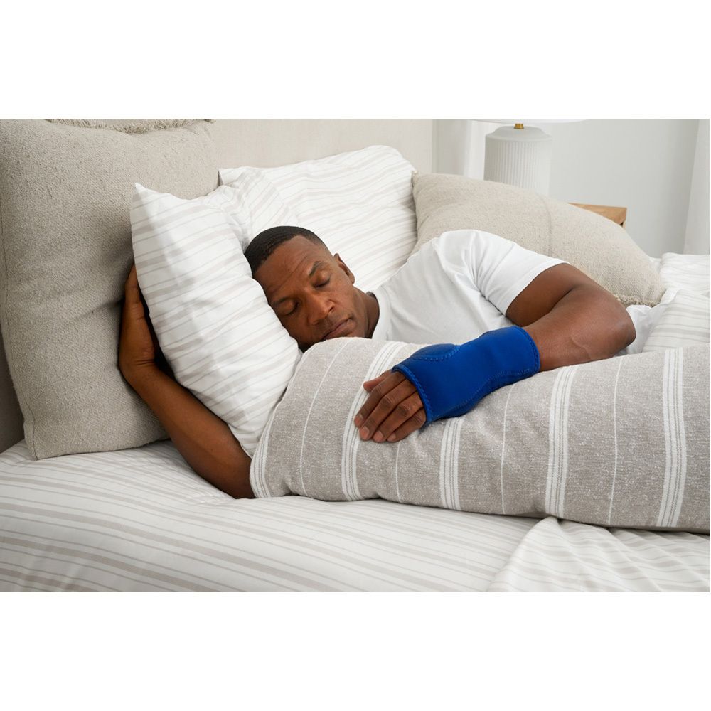 Emballage avec nom et marque du produit. Personne au lit avec attelle de poignet bleue. Illustration et instructions.