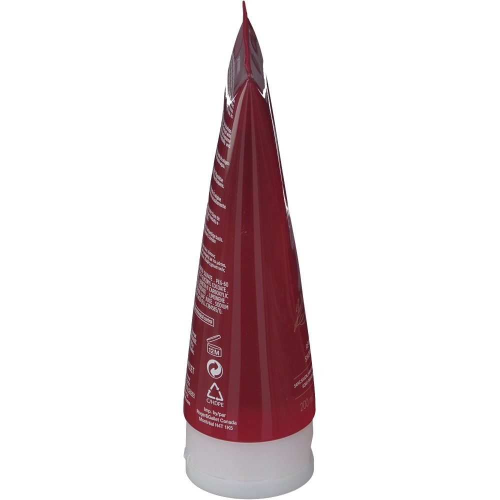 Vue latérale du tube. Tube rouge transparent avec bouchon blanc. Texte au dos.