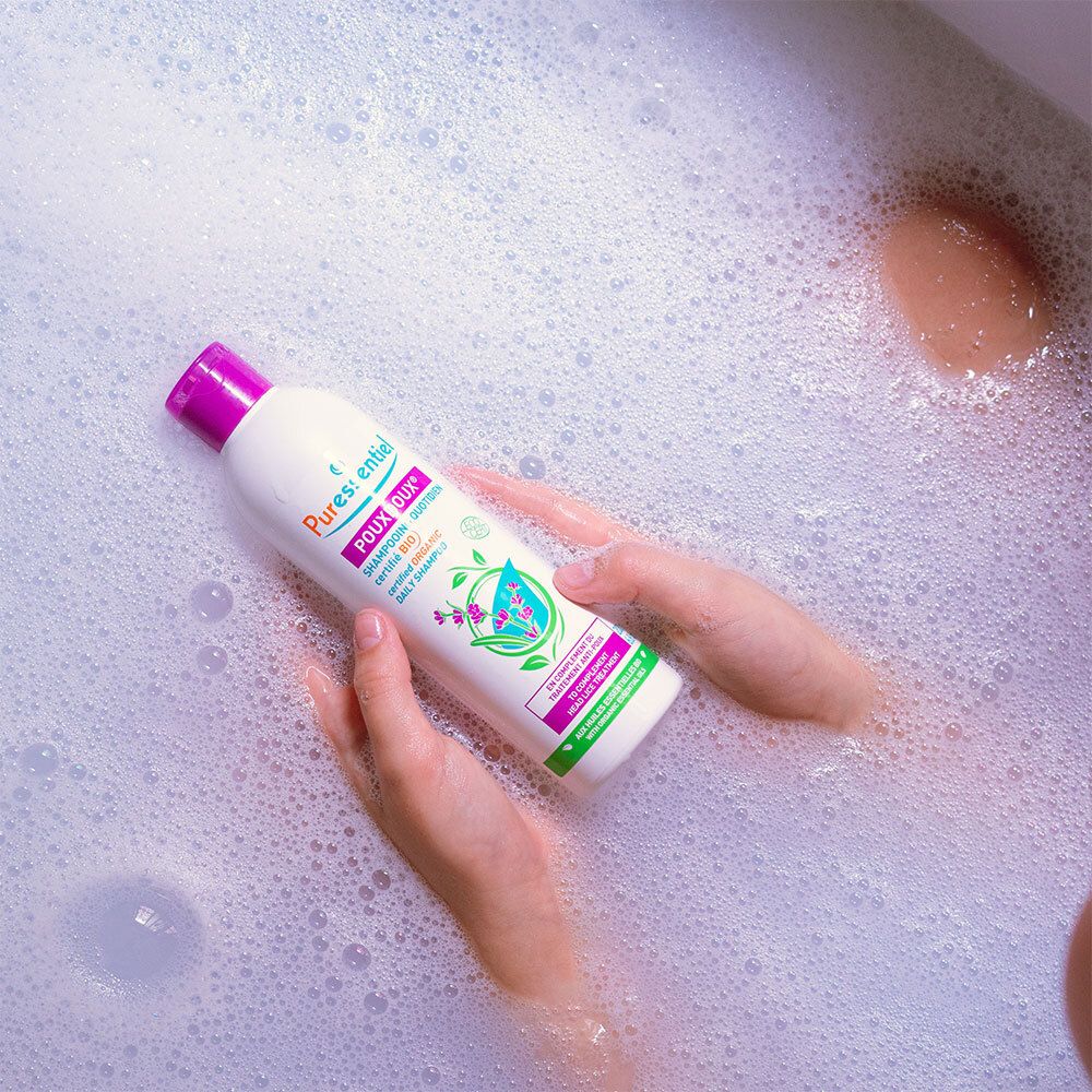 Person in Badewanne mit Shampoo-Flasche. Aufschrift: Puressentiel Poudoux®.