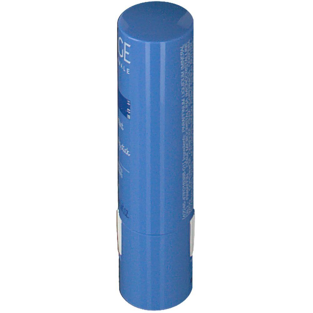 Stick bleu, vue latérale. Autocollant blanc avec texte. Logo Uriage et nom du produit partiellement visibles.