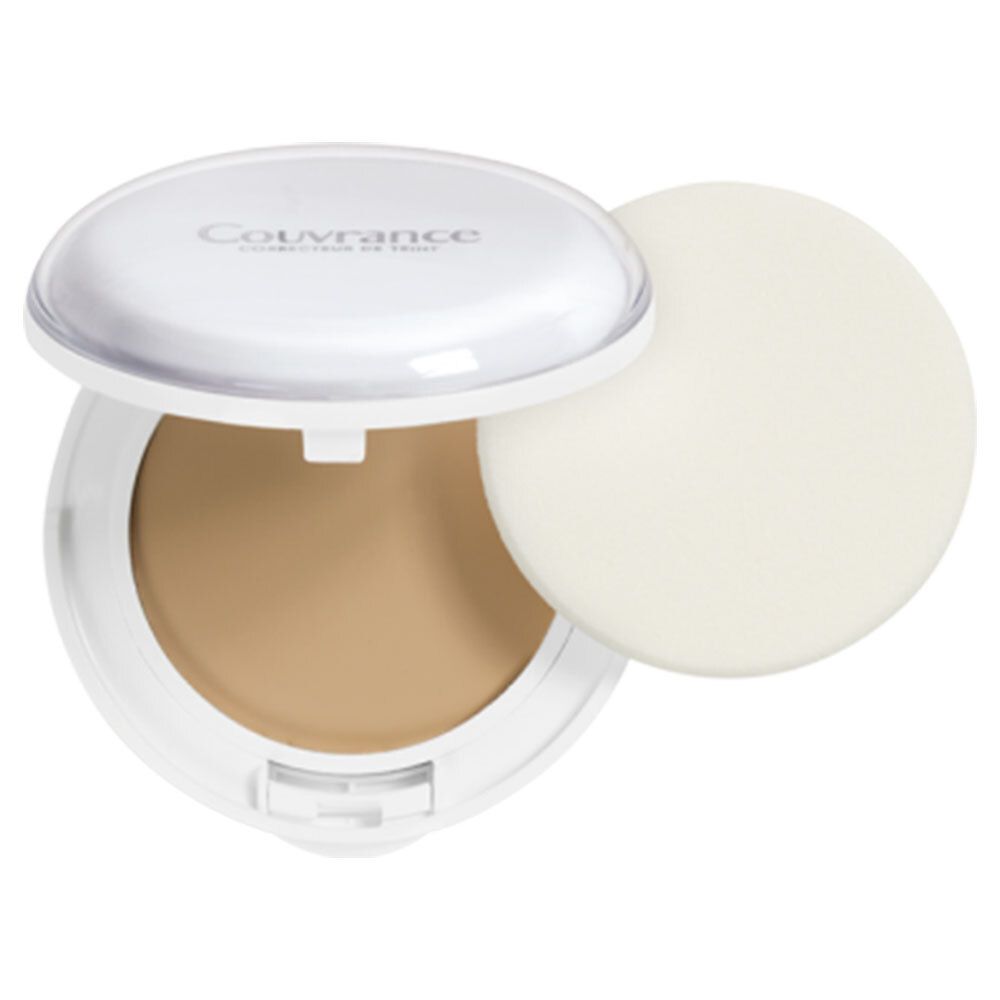 Maquillage compact dans un boîtier blanc ouvert. Contient du maquillage et une éponge. Couvercle avec texte.
