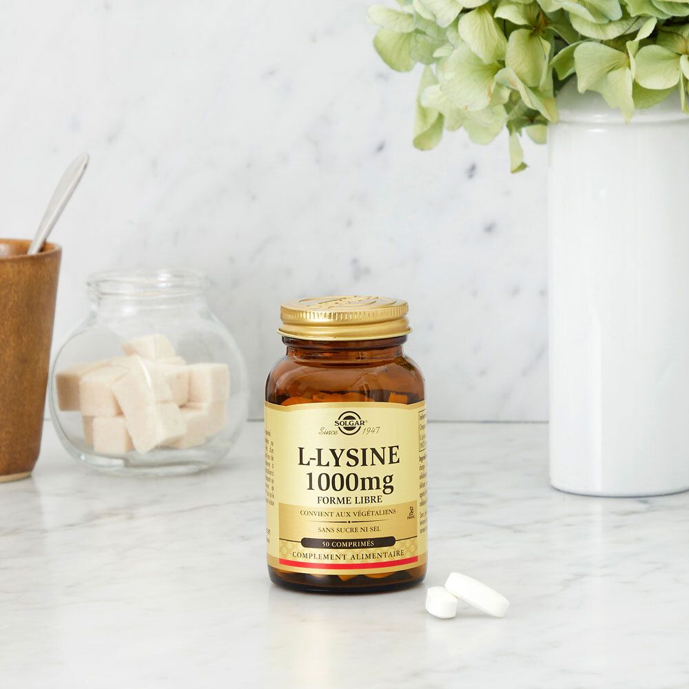Braune Flasche mit goldfarbenem Deckel auf einer Marmoroberfläche. Zwei Tabletten daneben.