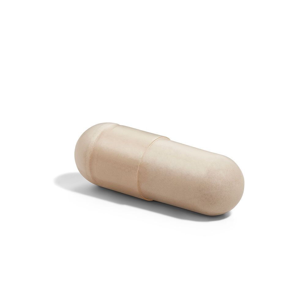 Eine einzelne, beige Kapsel. Zylindrische Form mit abgerundeten Enden.
