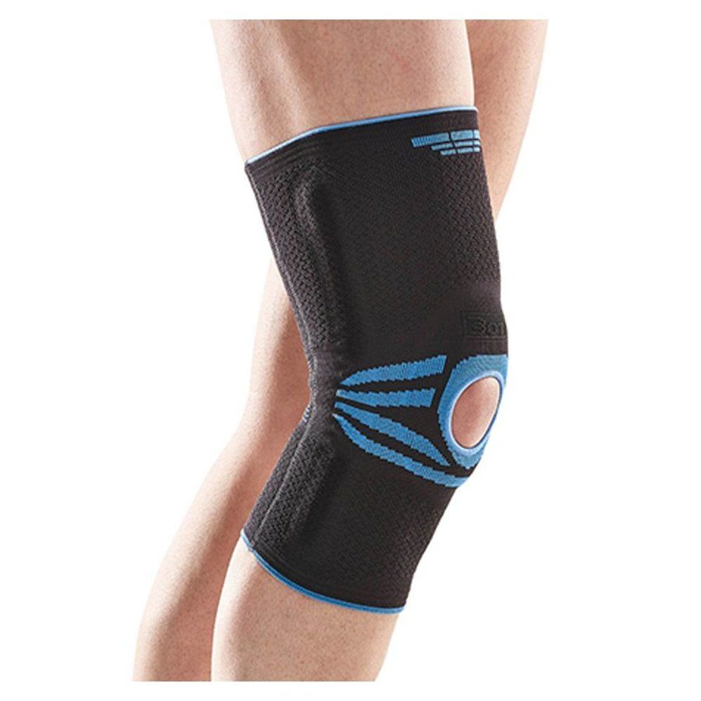 Genouillère noire avec des accents bleus. Portée sur une jambe. Détails bleus visibles et ouverture.