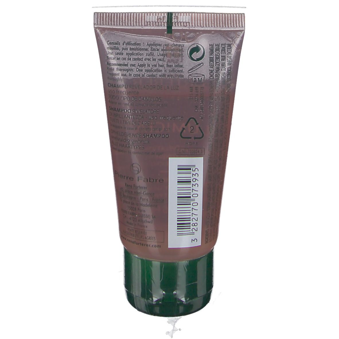 Dos du tube de shampooing. Texte et code-barres. Bouchon vert. Tube transparent avec shampooing brun.