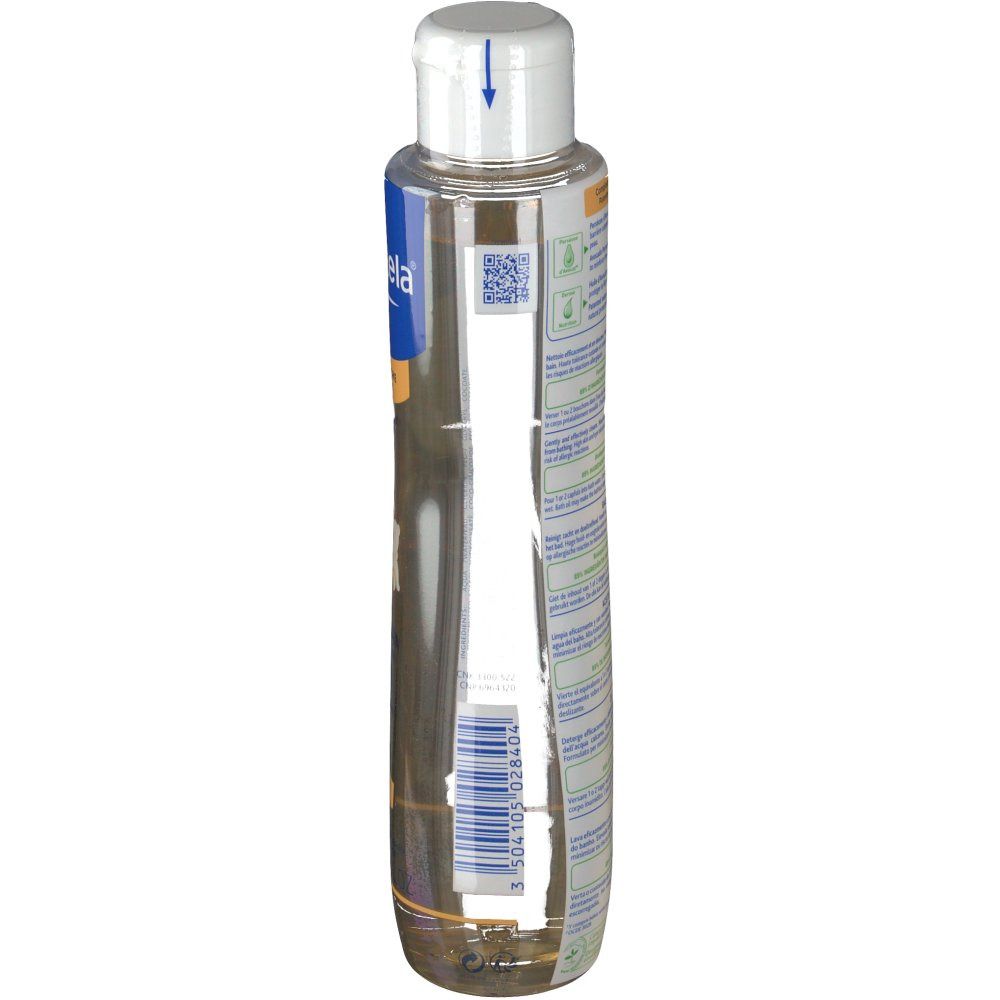 Flacon d'huile de bain Mustela, vue latérale. Étiquette bleue et blanche avec texte et code-barres. Liquide transparent. Bouchon blanc.