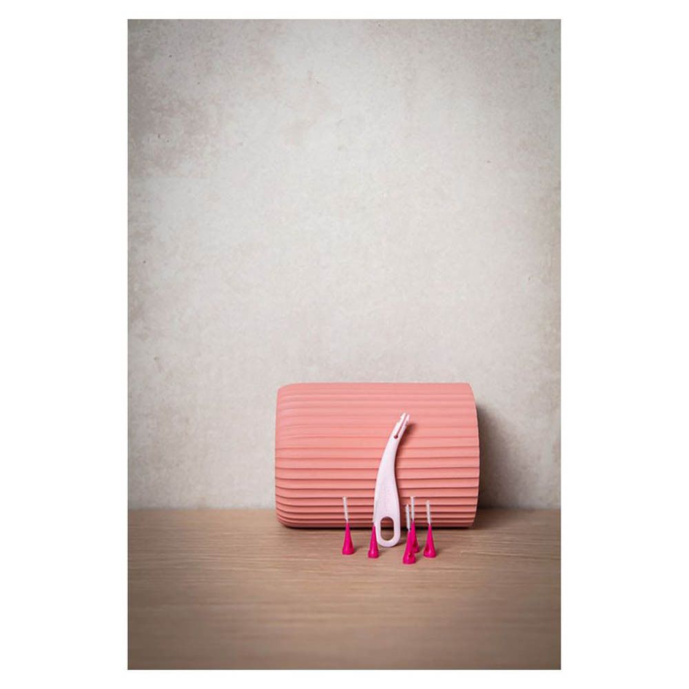 Jordan Interdentalbürsten, Größe S (0,4 mm) und Griff. Rosa Bürsten und Griff, auf einer Oberfläche platziert.