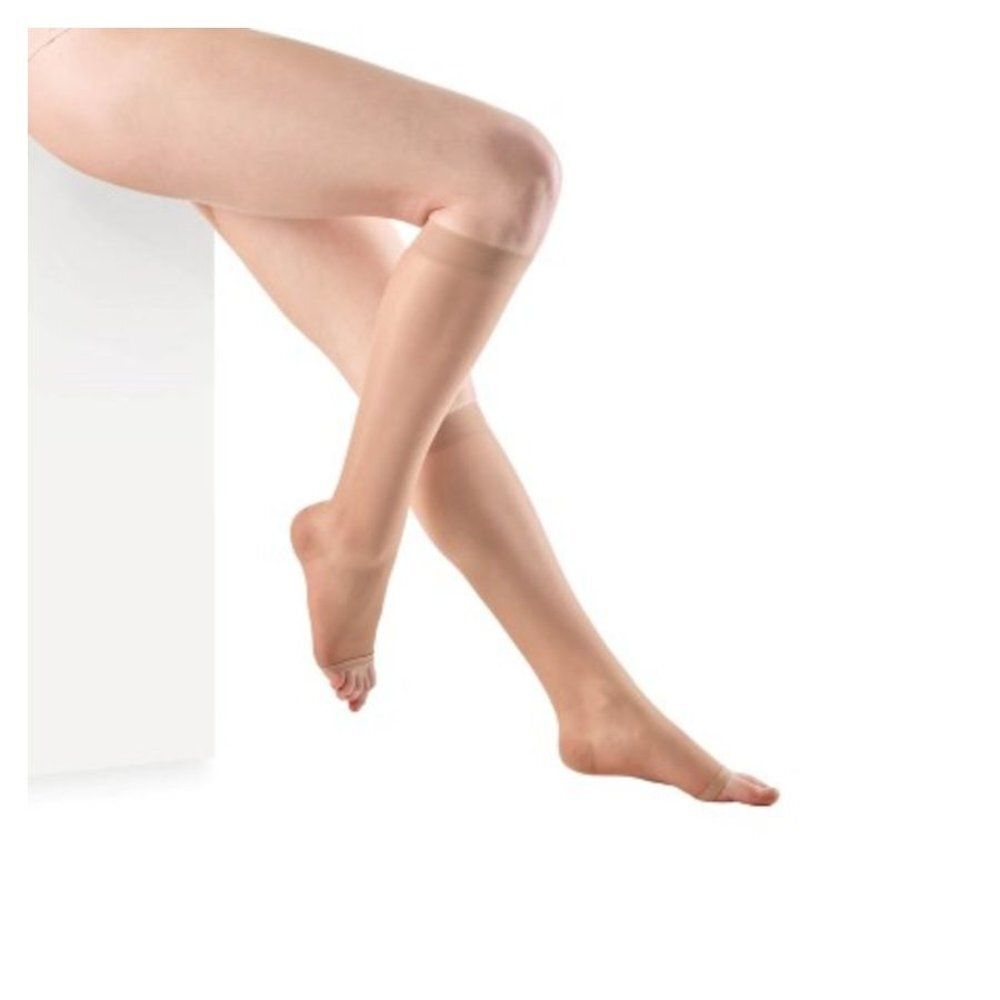 Jambes avec bas. Bas couleur chair, s'arrêtant au genou. Sur fond blanc.
