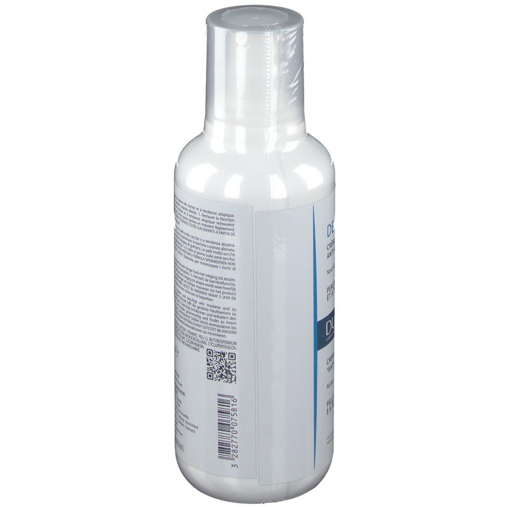 Weiße Flasche mit Text. Seitenansicht. DUCRAY DEXYANE Creme. Text in mehreren Sprachen.