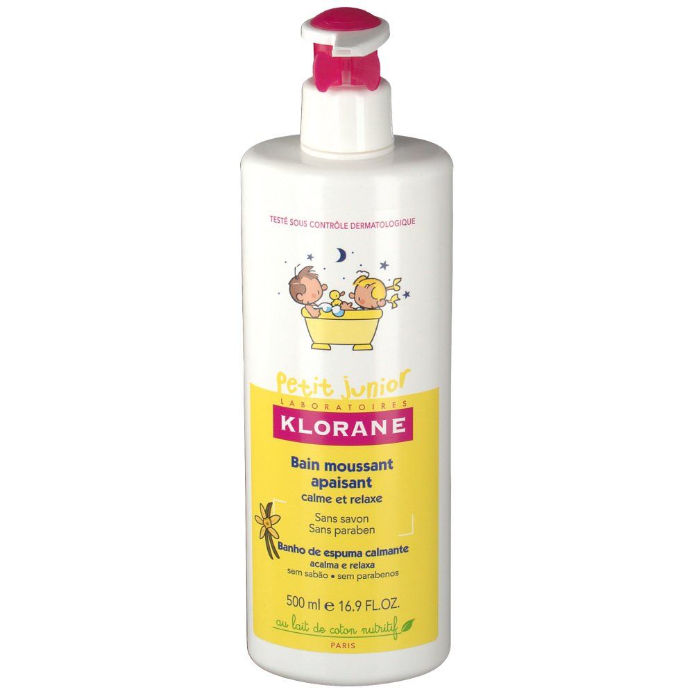 Weiße Flasche mit rosa Pumpkopf. Gelbes Etikett mit Text und Illustrationen. Aufschrift: Klorane Petit Junior, beruhigendes Schaumbad.