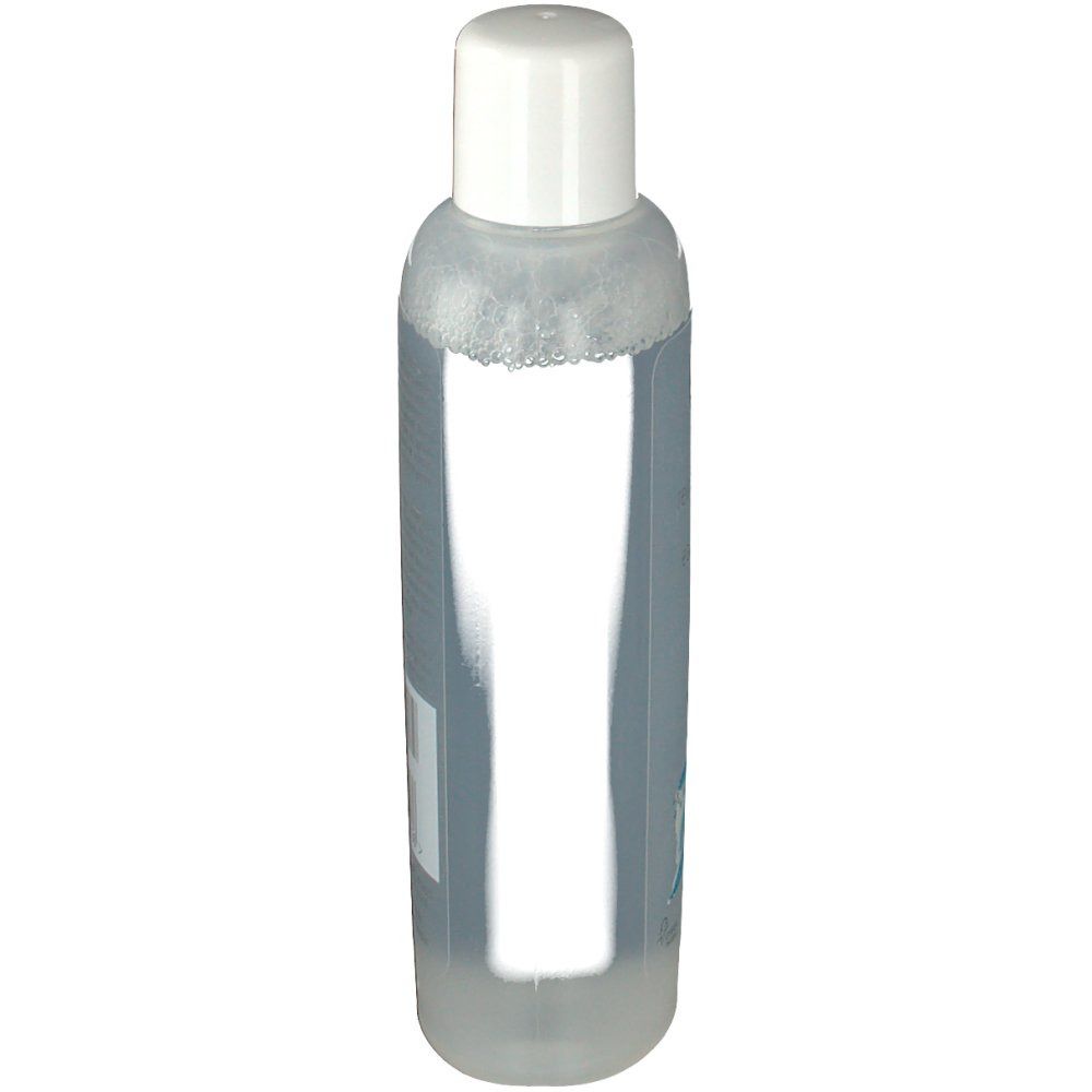 Durchsichtige Flasche mit weißem Deckel. Rückseite mit Etikett, Text und Barcode.