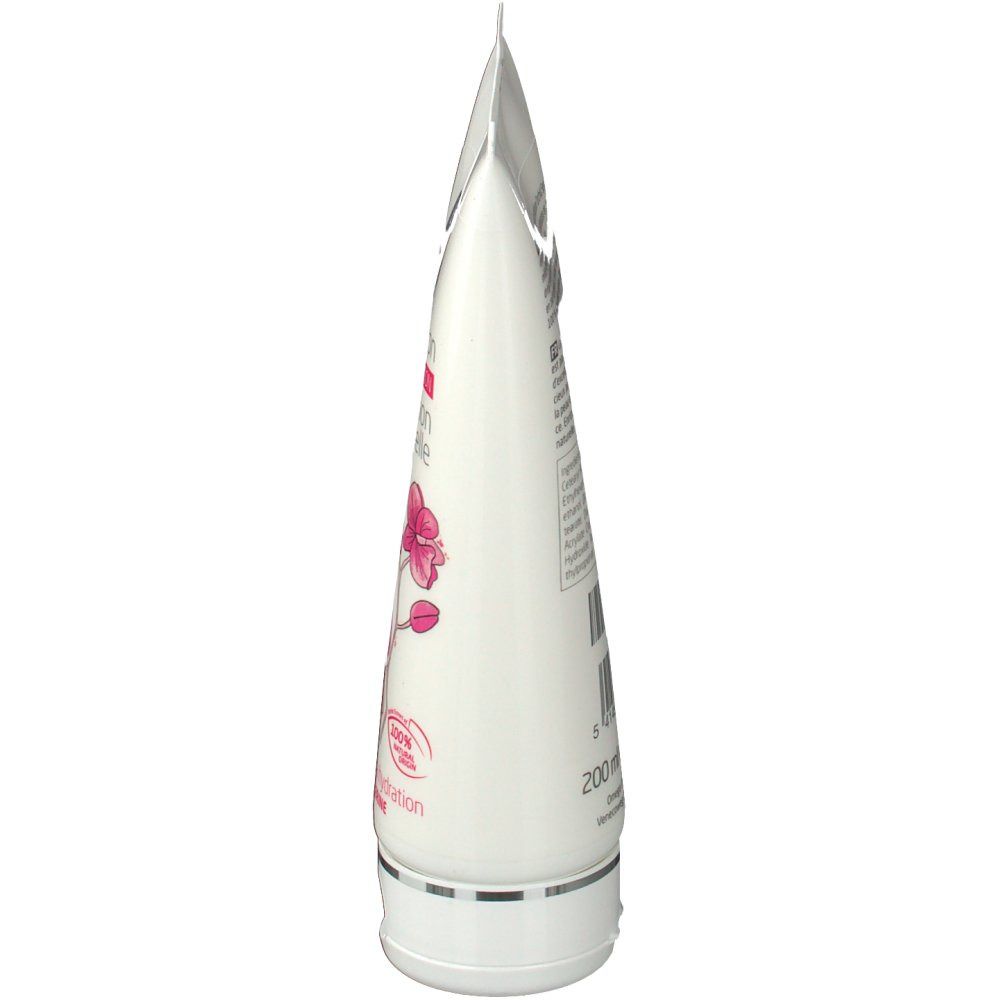 Seitenansicht einer weißen Tube. Enthält Text und eine Orchideen-Illustration.