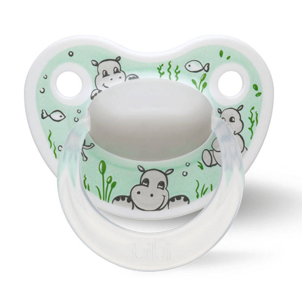 Sucette verte avec motifs hippopotames. Anneau transparent. Tétine blanche.