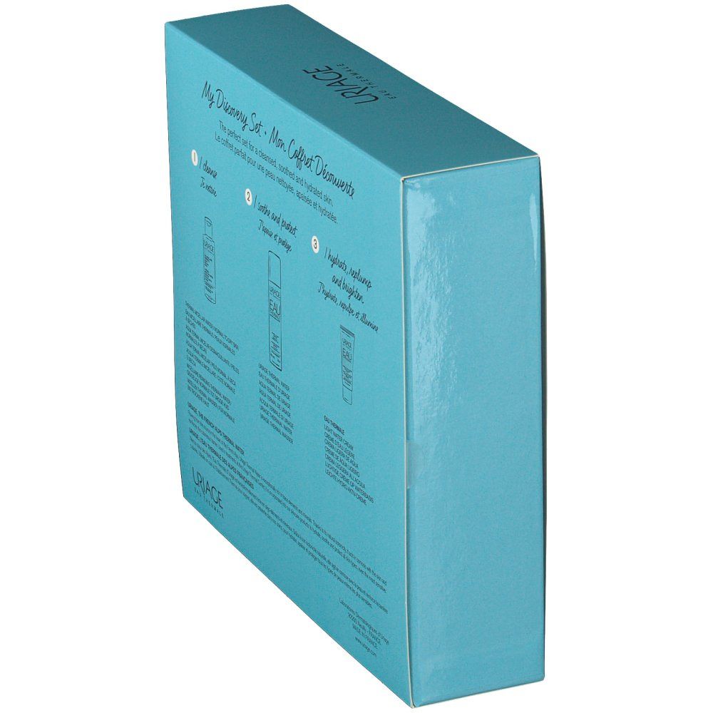 Coffret bleu clair, vue latérale. Texte et illustrations de produits. Logo Uriage en haut. Texte multilingue.