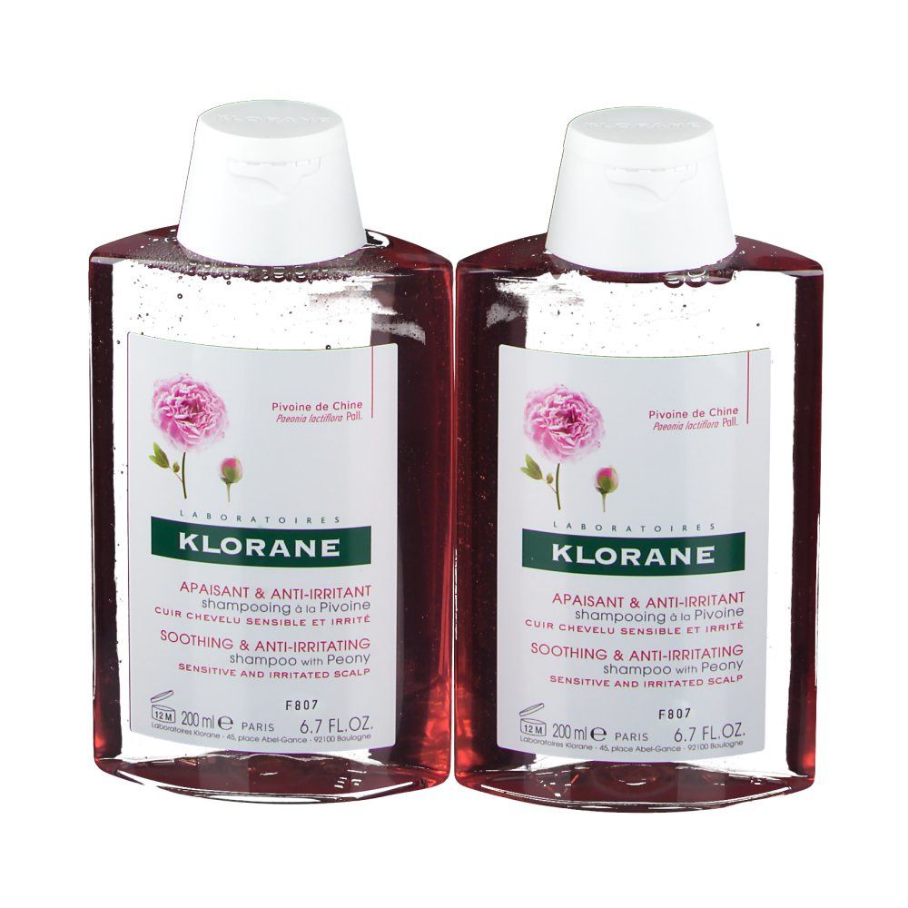 Zwei Flaschen Shampoo mit weißem Deckel. Etikett mit Text und Pfingstrosen-Abbildung. Produktname: KLORANE Shampoo mit Pfingstrose.