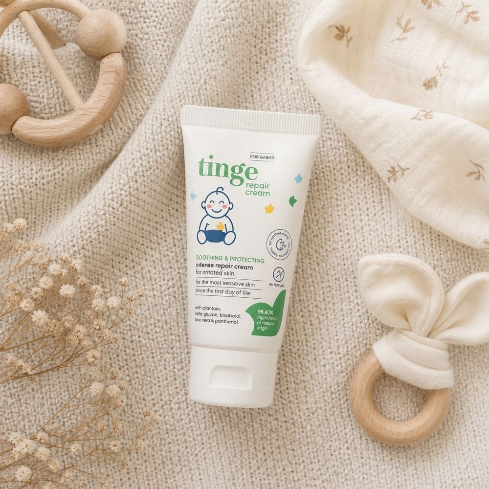 Tube blanc avec texte: Repair Cream, pour peaux sensibles. Illustration bébé. 96,40% d'origine naturelle.