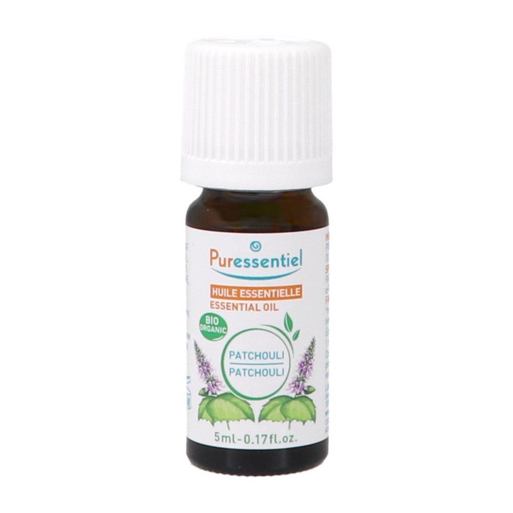 Flacon d'huile essentielle Puressentiel Patchouli avec feuilles de patchouli fraîches.