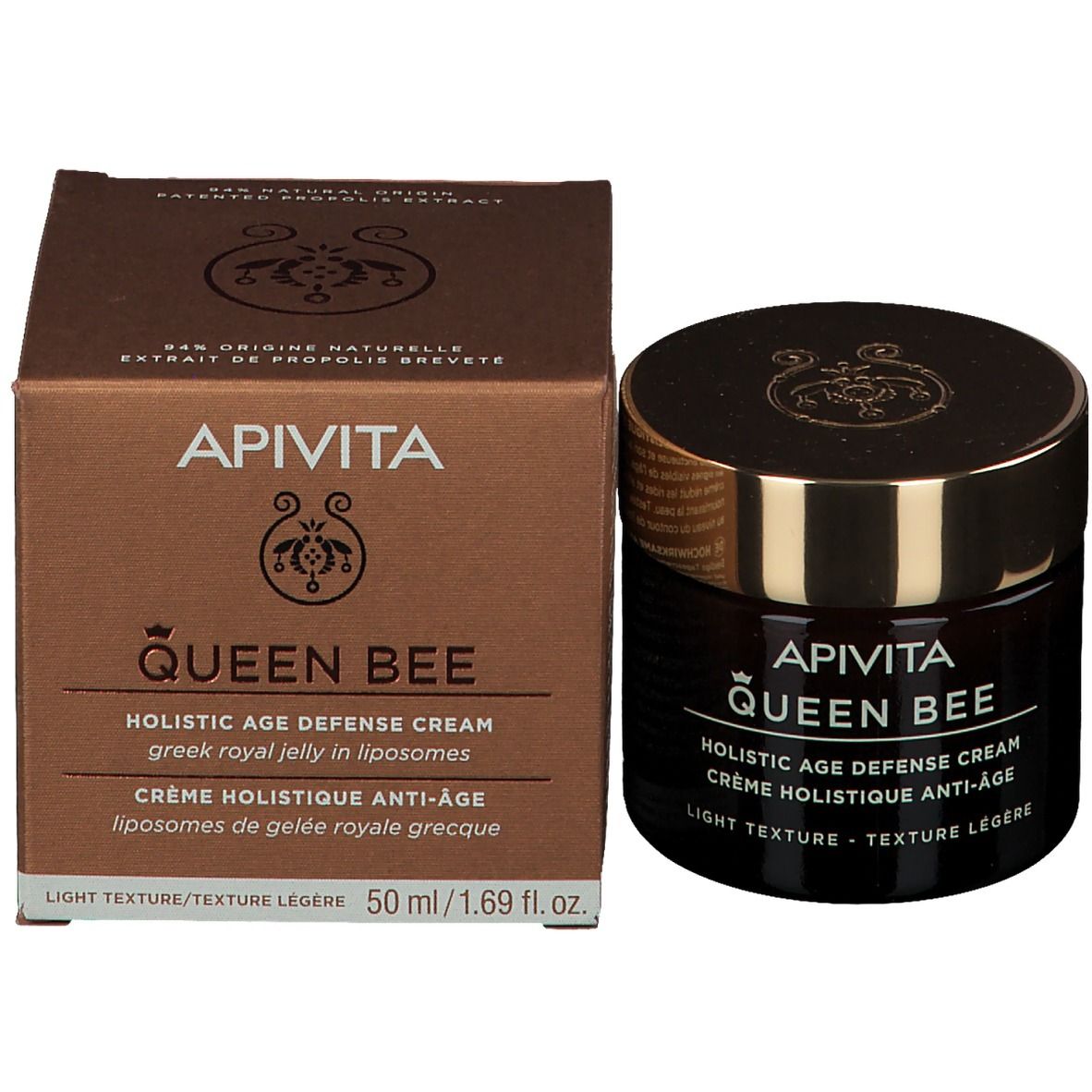 Dunkles Glas und Karton. Aufschrift: APIVITA Queen Bee, Holistic Age Defense Cream, 50 ml. Text in Englisch und Französisch.