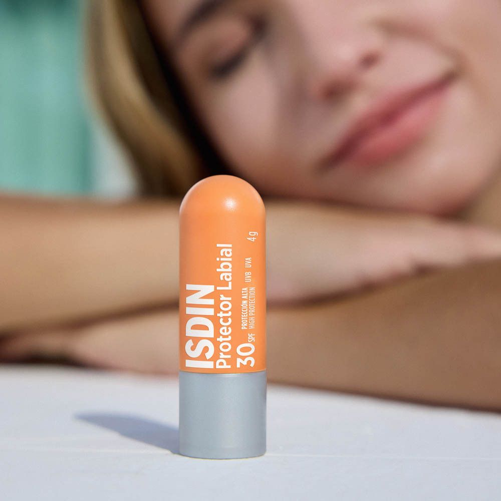 Lippenpflegestift. Orangefarbener Stift mit grauem Boden. Text: Aangename textuur met onzichtbare finish.