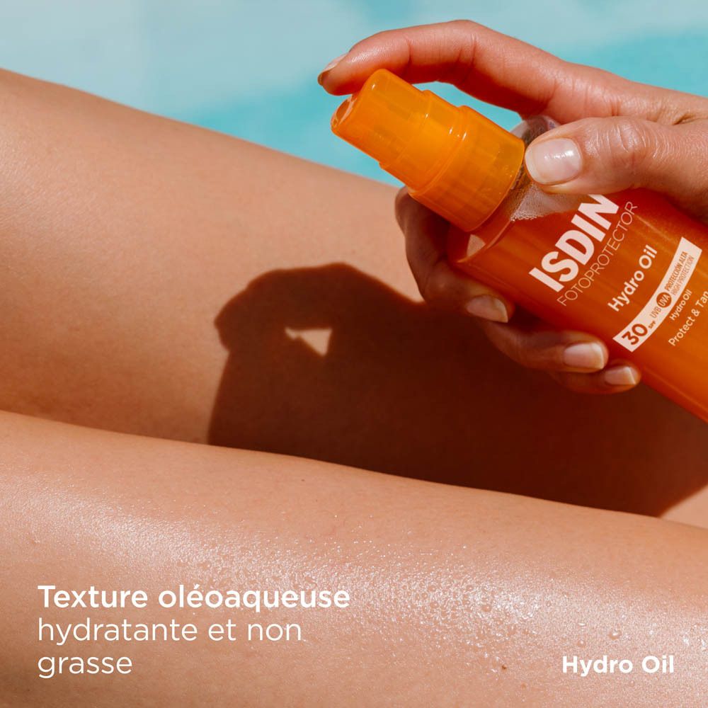 FOTOPROTECTOR ISDIN HydroOil SPF 30 appliqué sur une jambe. Texte: Texture huileuse, hydratante.