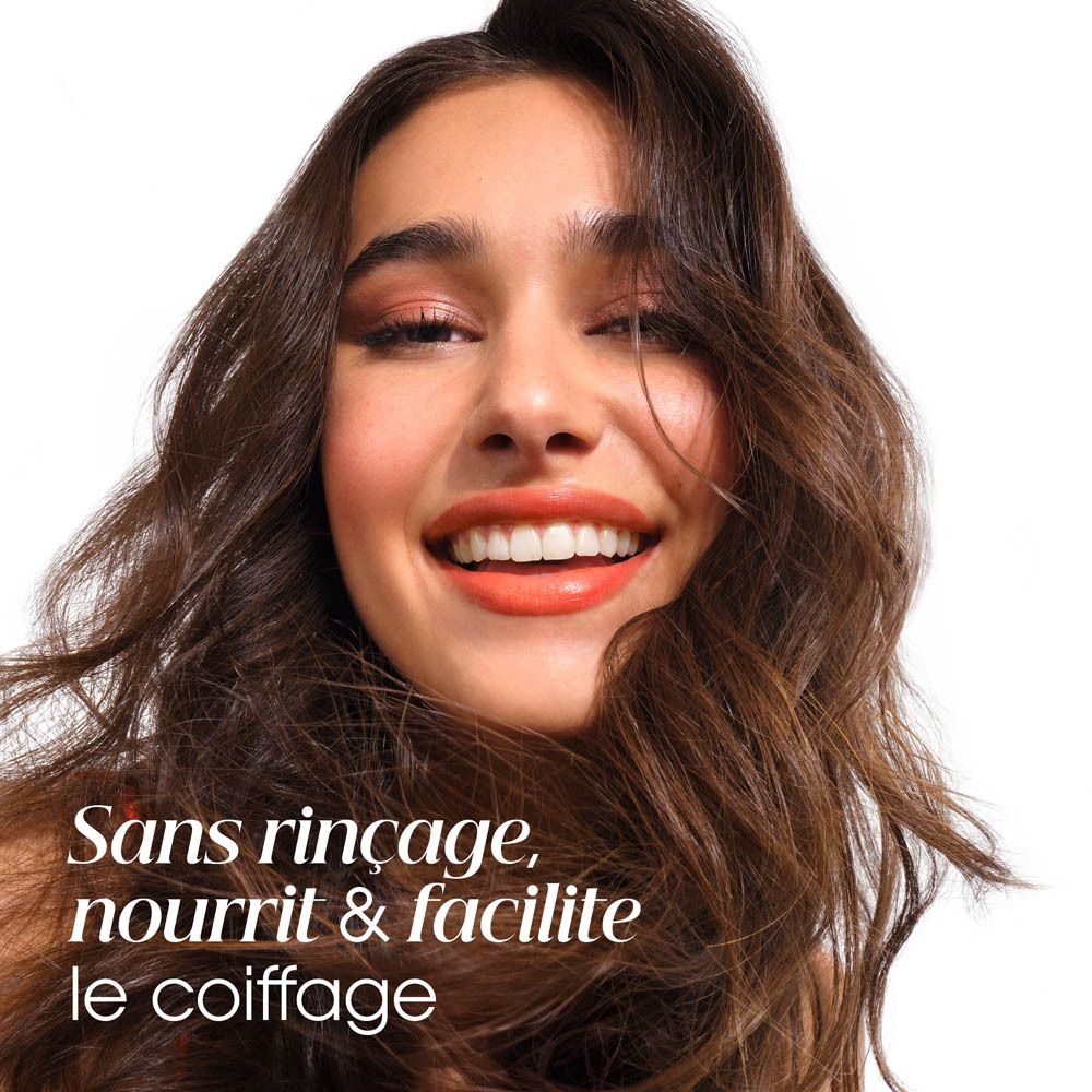 Portrait d'une femme souriante aux cheveux bruns. Texte : Sans rinçage, nourrit & facilite le coiffage.