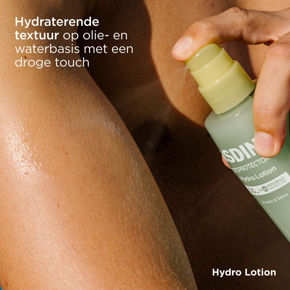 ISDIN Hydro Lotion SPF 50+ wird auf Arm gesprüht. Gelb-grüne Flasche. Text.