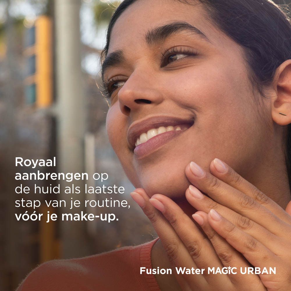 Frau trägt ISDIN Fotoprotector Fusion Water Magic Urban auf. Gesicht. Hintergrund: Gebäude.