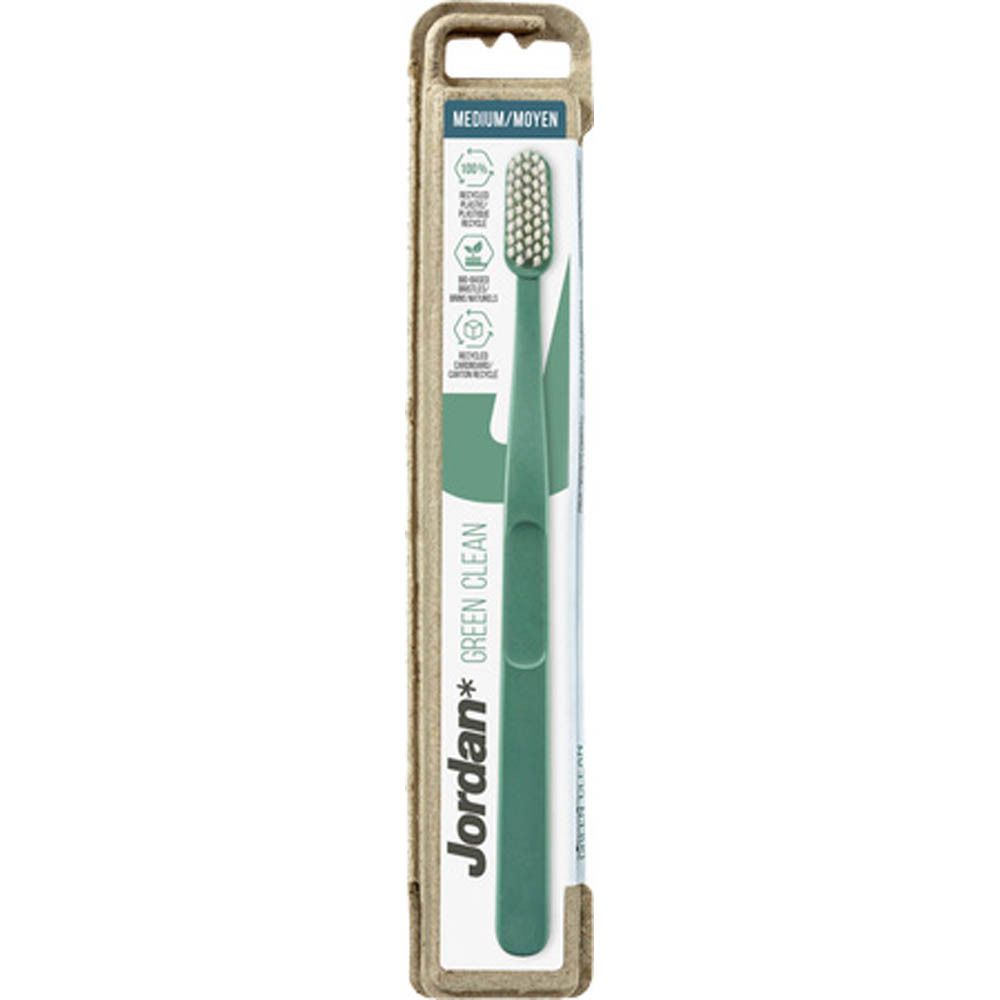Brosse à dents verte dans un emballage en carton. Inscription : Jordan Green Clean, Medium. Emballage avec symboles de recyclage.