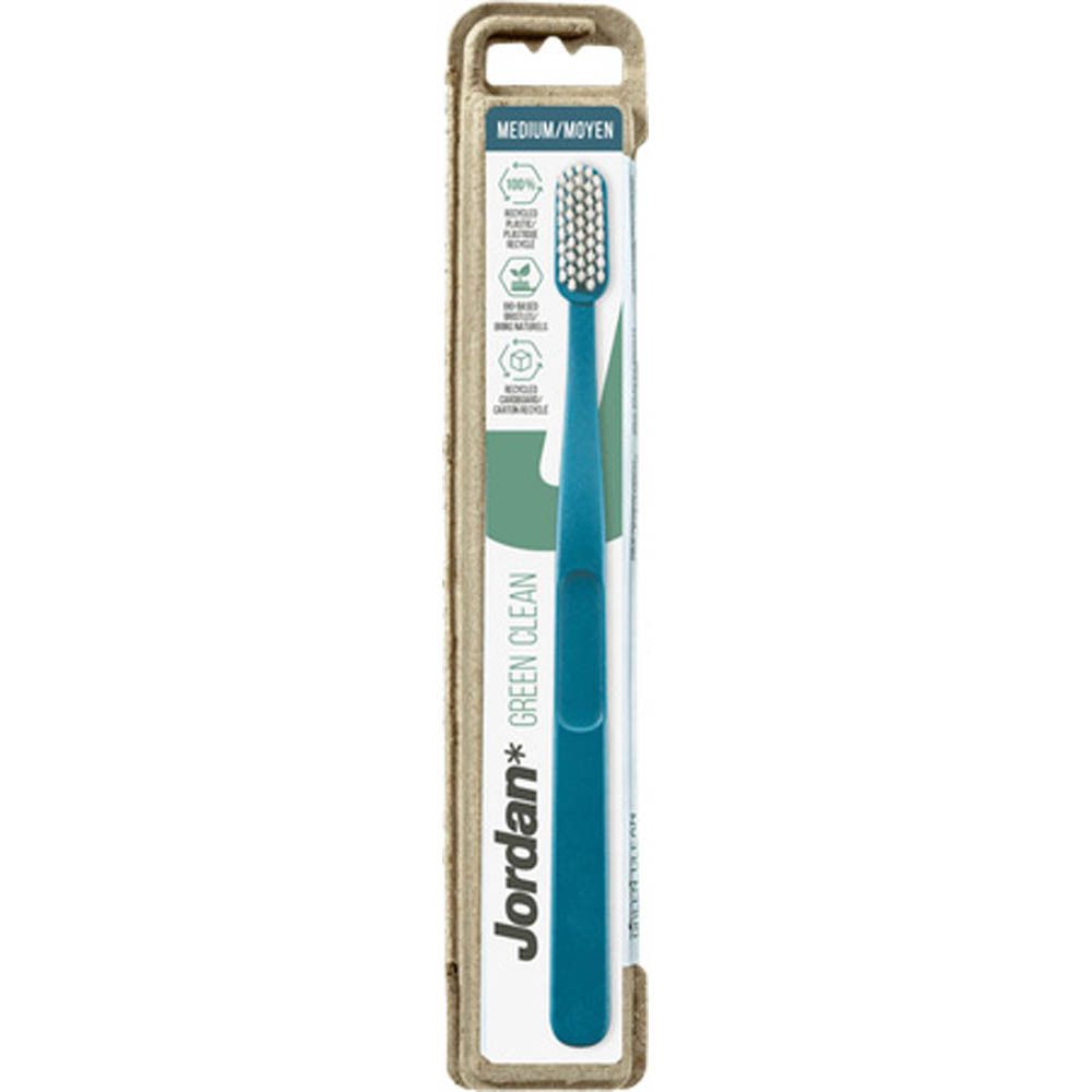 Brosse à dents bleue dans un emballage en carton. Inscription : Jordan Green Clean, Medium. Emballage avec symboles de recyclage.