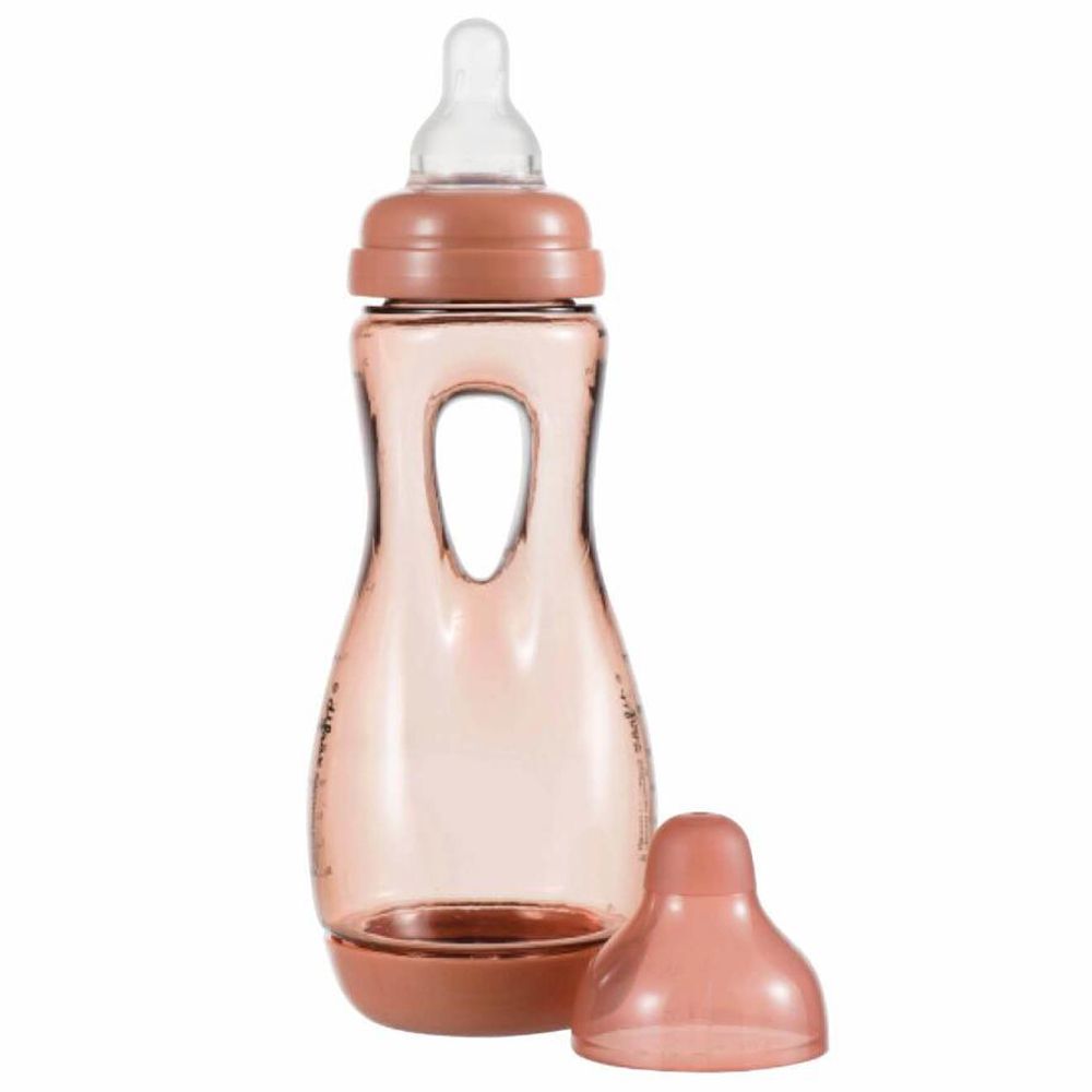 Biberon rose avec poignée et tétine. Couvercle à côté.