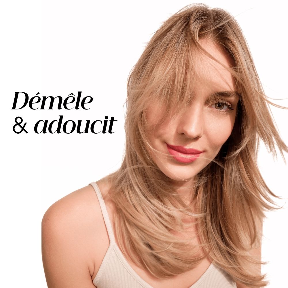 Femme aux cheveux soyeux, brillants et faciles à démêler après utilisation du produit KLORANE.
