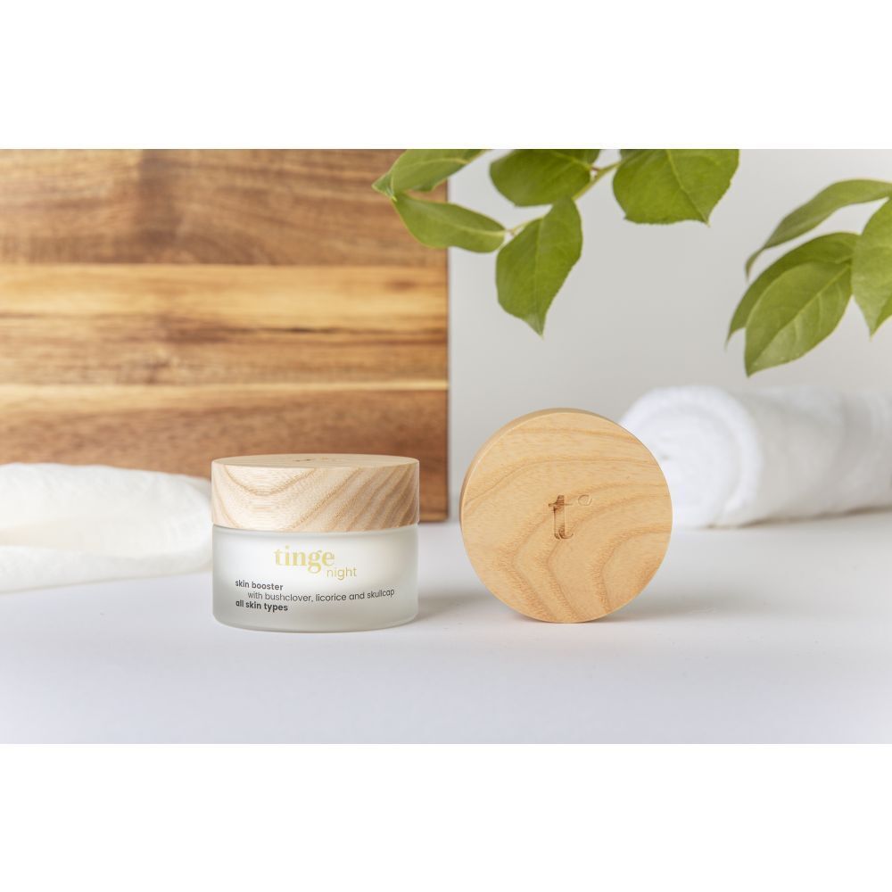 Pot de crème avec couvercle en bois et couvercle séparé. Inscription : skin booster, avec trèfle des buissons, réglisse et scutellaire.