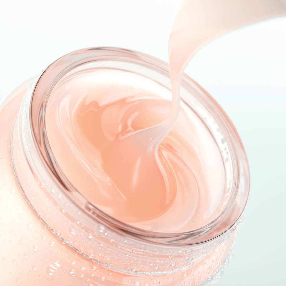 Ein Glas mit rosafarbener Creme, die herausfließt. Wassertropfen auf dem Glas.