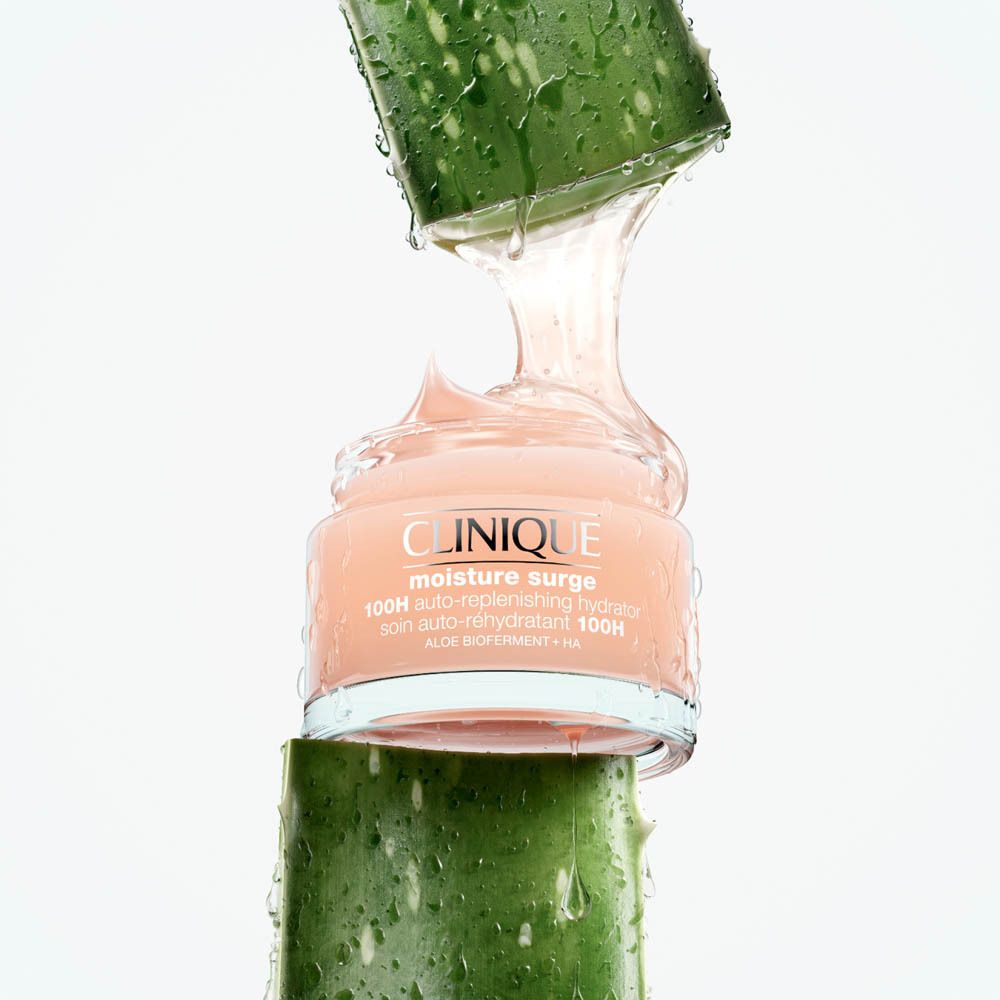 Clinique Moisture Surge Feuchtigkeitscreme in einem rosa Tiegel, umgeben von Aloe Vera.
