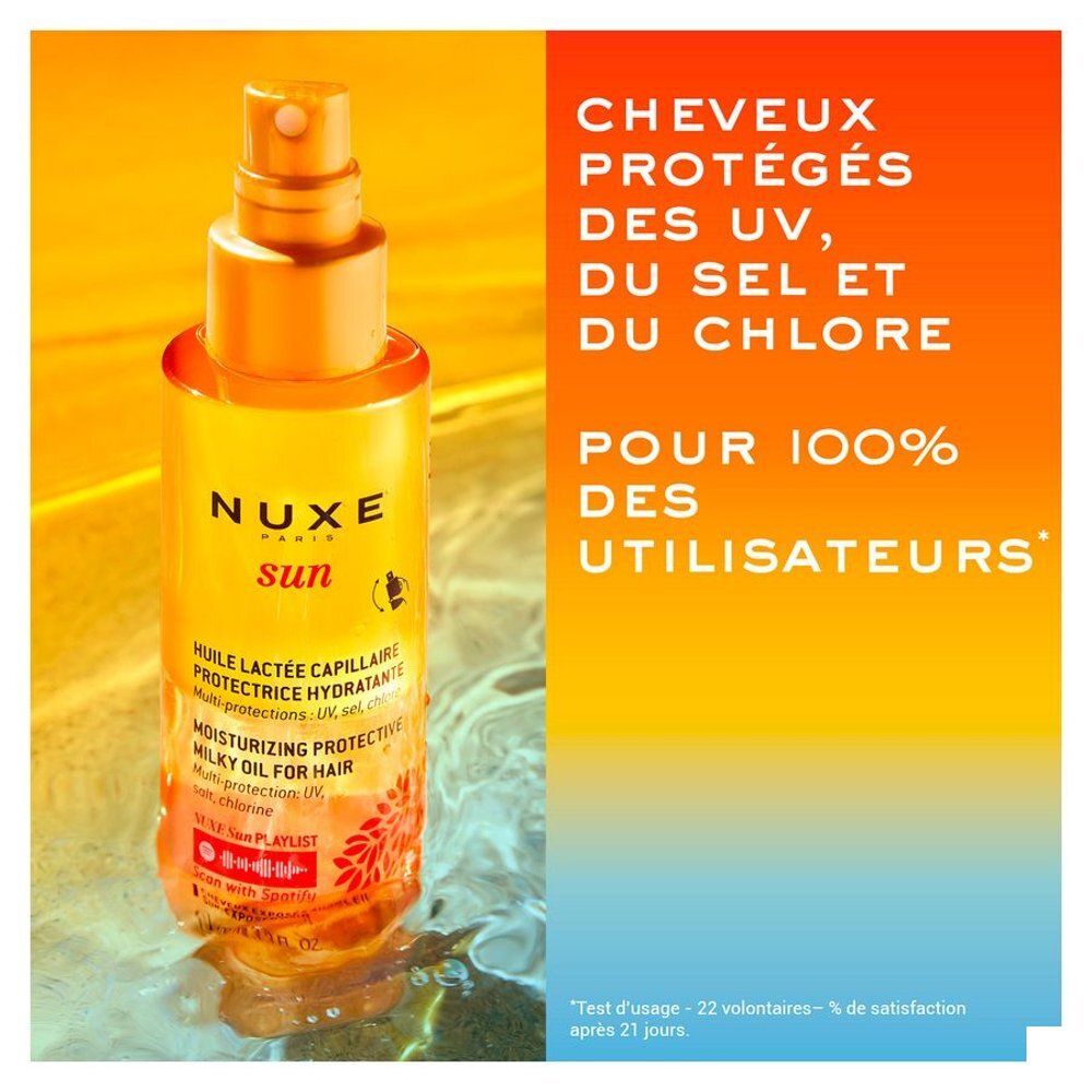 Gros plan du liquide doré dans le flacon d'huile Nuxe Sun pour cheveux.