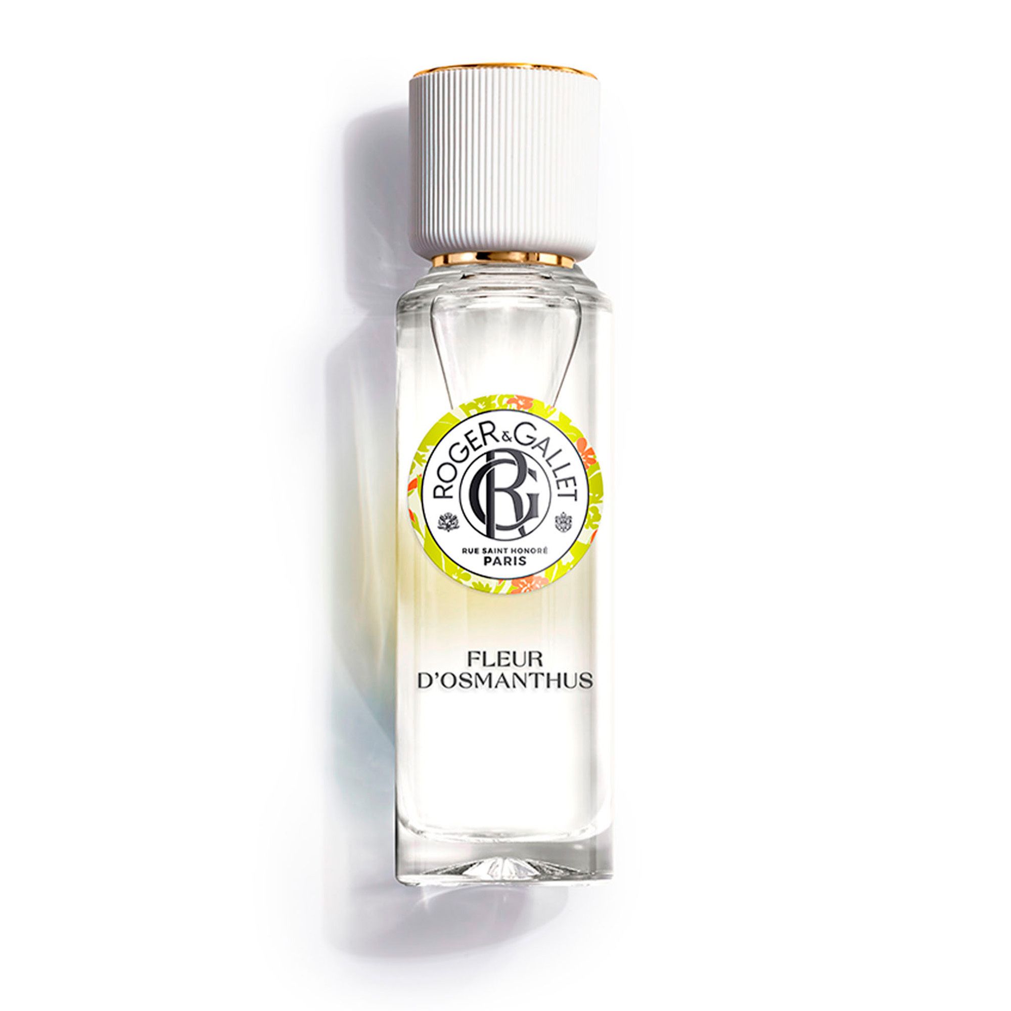Flacon avec bouchon blanc et capuchon doré. Inscription: FLEUR D'OSMANTHUS. Logo et texte.
