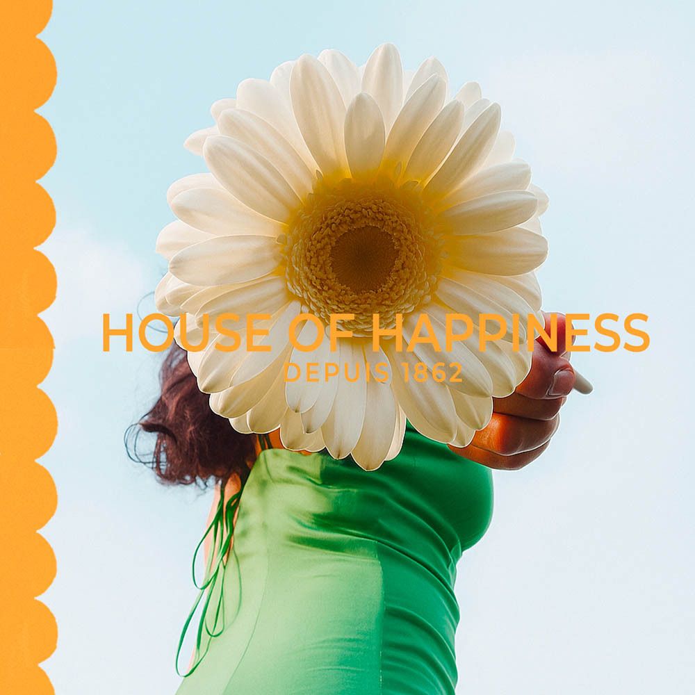 Femme tenant une fleur devant son visage. Texte: House of Happiness, Depuis 1862.
