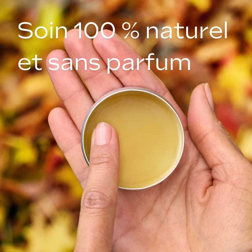 Mains tenant un pot de baume ouvert. Texte: 100% naturel et sans parfum. Fond: feuilles d'automne.